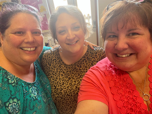 Three women posing together for a selfie indoors.